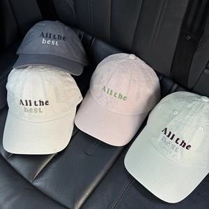 Detailed view of four colorful cotton baseball caps with All the Best embroidery