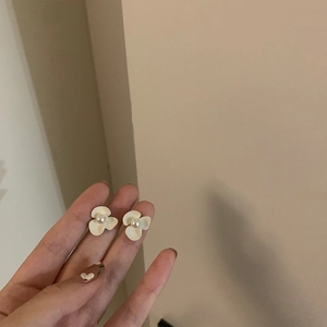 Vue détaillée de boucles d'oreilles fleur faites main avec pétales crème et perle