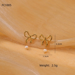 Detailed view of golden bow earrings with pearls and size specs 2.2cm x 1.5cm
