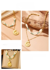Detail of double-layer stainless steel necklace with seashell and turquoise stone accents