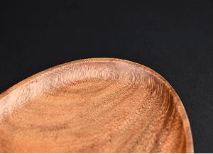 Close-up of walnut wood tray featuring a curved raised edge design for anti-slip safety