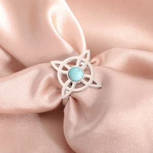 Silver stainless steel open ring with blue stone and witch knot design on pink silk