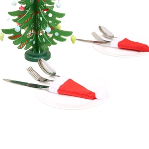 Mini Christmas hats cutlery holder and small tree set on a white dinner plate