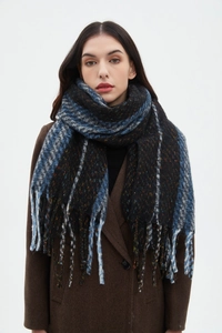 Detail shot of navy and black checkered knit scarf with tassels worn by a model