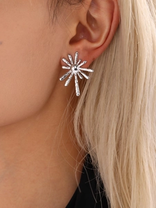 Detailed close-up of a silver sunburst earring with textured molten finish on ear