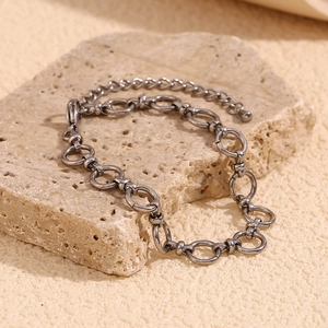 Detailed close-up of dark silver chain link bracelet with lobster clasp on stone