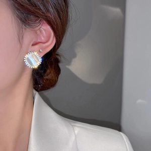 Elegant gold plated round earrings with white cat eye stone and sparkling crystals