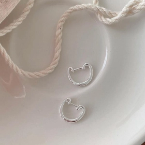 Minimalist 925 sterling silver hoop earrings with polished finish on a ceramic plate