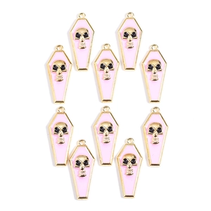 Detail of pink enamel coffin charms with skull motifs for Halloween necklace DIY