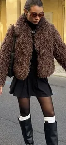 Street style shot of brown faux fur jacket with black leather boots and a mini skirt