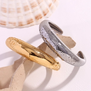 Detail of gold and silver waterproof stainless steel bangles with water droplets