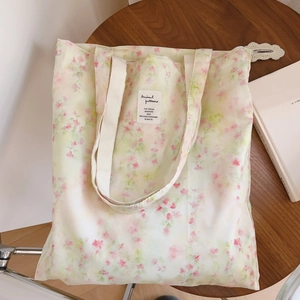 Détail du sac cabas en coton à fleurs avec motif vintage sur une table en bois rustique