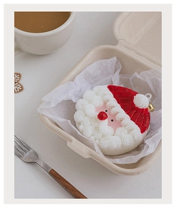 Détail de la bougie parfumée Père Noël avec clochette dorée dans un emballage cadeau éco