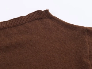 Detailed close-up of brown off-shoulder neckline with ribbed knit fabric texture