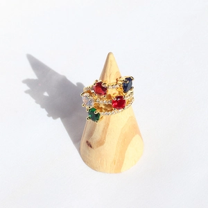 Detailed view of gold multi-color gemstone ring with zircons on wooden display