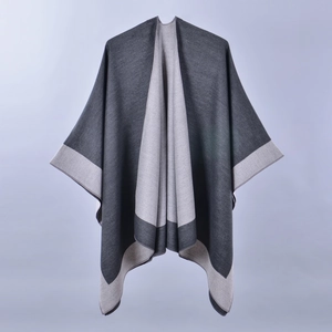 Detailed view of the soft grey split poncho with two-tone color block design and texture