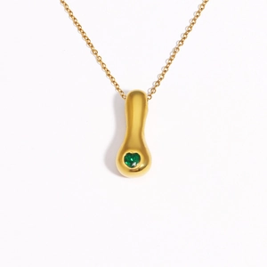Detail of 18k gold plated necklace with teardrop pendant and heart-shaped green gem