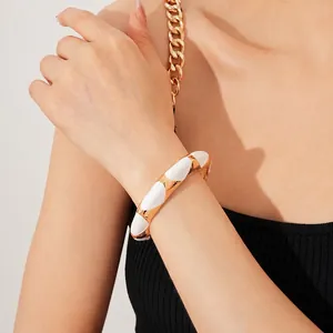 French vintage gold open bangle with white enamel inlay on a female model