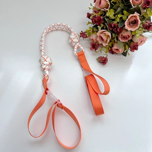 Detail of white braided cord with orange dots and durable nylon loops on white desk