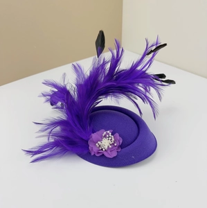 Detail of a purple vintage fascinator hat with elegant ostrich feathers and pearl flower.