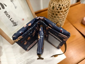 Detail view of the trifold wallet interior with card slots and floral canvas pattern