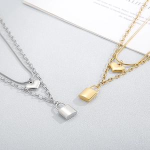Double-layered stainless steel necklace featuring heart and lock pendants in gold and silver