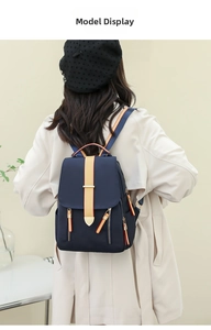Navy blue oxford backpack with contrast straps shown on model in home studio setting