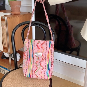 Détail du sac cabas en tricot rose avec coutures ondulées colorées et étiquette en tissu