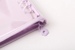Close-up of A5/A6 PVC binder featuring purple fabric trim and a flower zipper pull