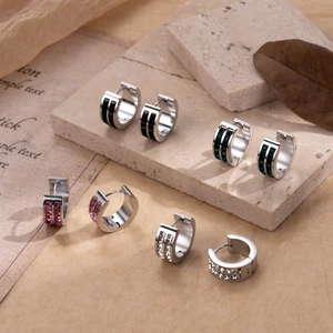 Chic double-row zircon hoop earrings in four colors on a textured stone display
