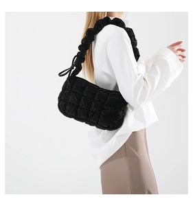 Detail showing the quilted cloud texture and gathered elastic strap of this black bag