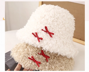 Détail de chapeaux bob en peluche avec nœuds à pois rouges en blanc et coloris kaki