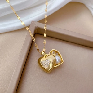 Macro view of gold heart locket necklace with sparkling zircons and a pearl inside