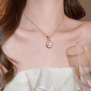 Detail einer eleganten Goldkette mit Perlenanhänger in Form eines Glücksbeutels