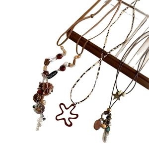 Three Bohemian necklaces with feather and star charms on leather and wooden bead cords