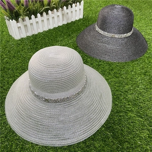 Detailed close-up of wide-brim straw sun hats featuring sequined rhinestone bands
