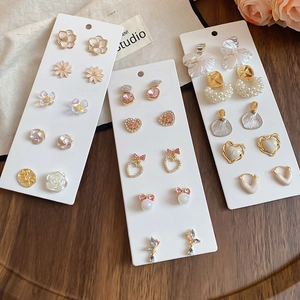 Close-up of 10-piece earring set featuring bowknot, pearl and heart designs on a card