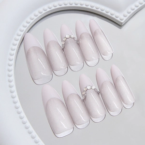 French cat eye press-on nails with white tips and pearl accents on a display tray