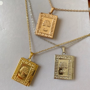 Detail of 18K gold and silver tree of life book-shaped locket pendants on O-chains