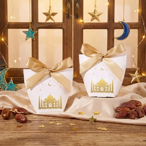 Detail of white Eid gift box with gold foil castle design and champagne silk ribbon