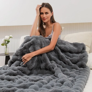 Macro shot of dark grey thick plush blanket with unique 3D wave pattern and fur texture