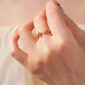 Detail eines Vintage Goldstern Rings mit orangefarbenen und roten Zirkonsteinen