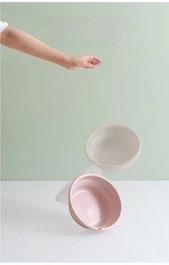 Detail of a pink foldable washbasin showing thickened edges and durable collapsible structure
