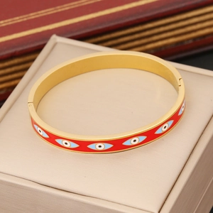 Detail of gold evil eye bangle with red enamel inlay on professional jewelry display