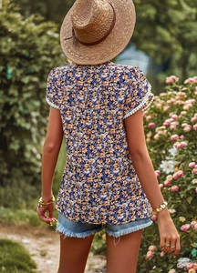 Back view of a navy floral blouse featuring delicate white lace trim on sleeves