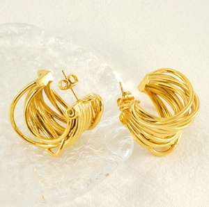 Macro detail of 18K gold-plated C-shaped earrings with a multilayer woven texture