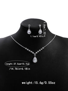 Macro shot showing dimensions of silver zircon flower necklace and teardrop tassel earrings