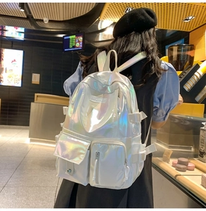 Detail view of holographic laser PU backpack with iridescent sheen and front zip pocket