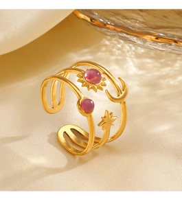 Close-up of golden adjustable ring with celestial sun moon star motifs and pink gemstones