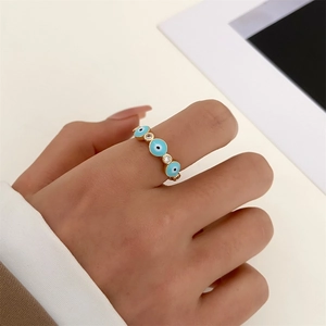 Close-up of golden evil eye ring with blue enamel and sparkling micro-inlaid zircons